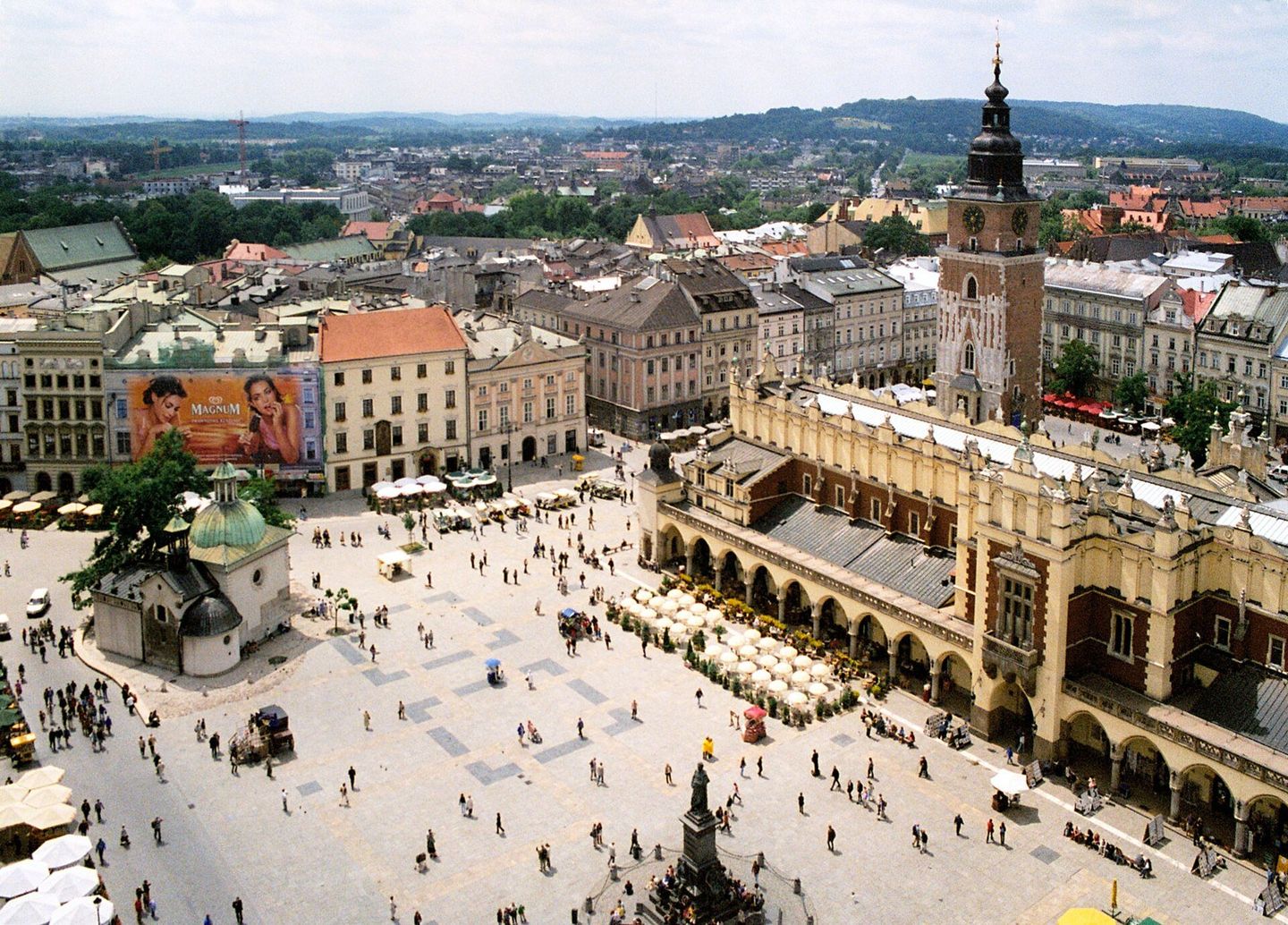 The Main Square of Kraków's Old Town seen from St. Mary's Basilica tower, with the Cloth Hall's arched trading arcade running down the middle and the Town Hall Tower and Church of St. Adalbert to one side