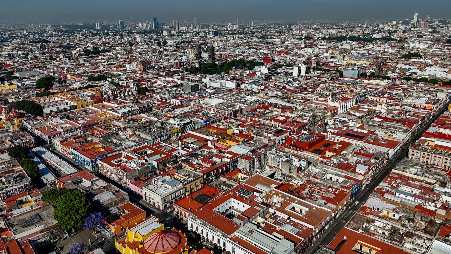 Aerial drone view over the domes, church towers and grid-plan rooftops of Puebla's historic centre, Mexico