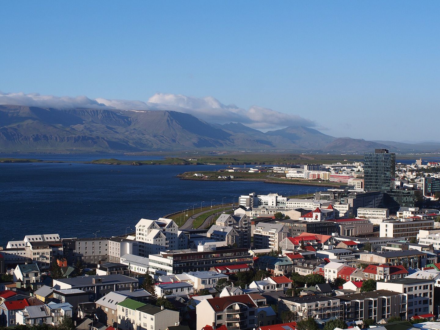 View over the brightly coloured corrugated-iron rooftops of central Reykjavík from the tower of Hallgrímskirkja, with the harbour and Mount Esja beyond